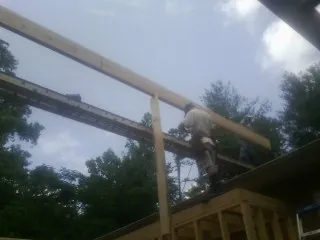 Carpenter setting a ridge beam over a new addition frame — Ice Dam Removal by Roofing Brothers in Kauneonga Lake