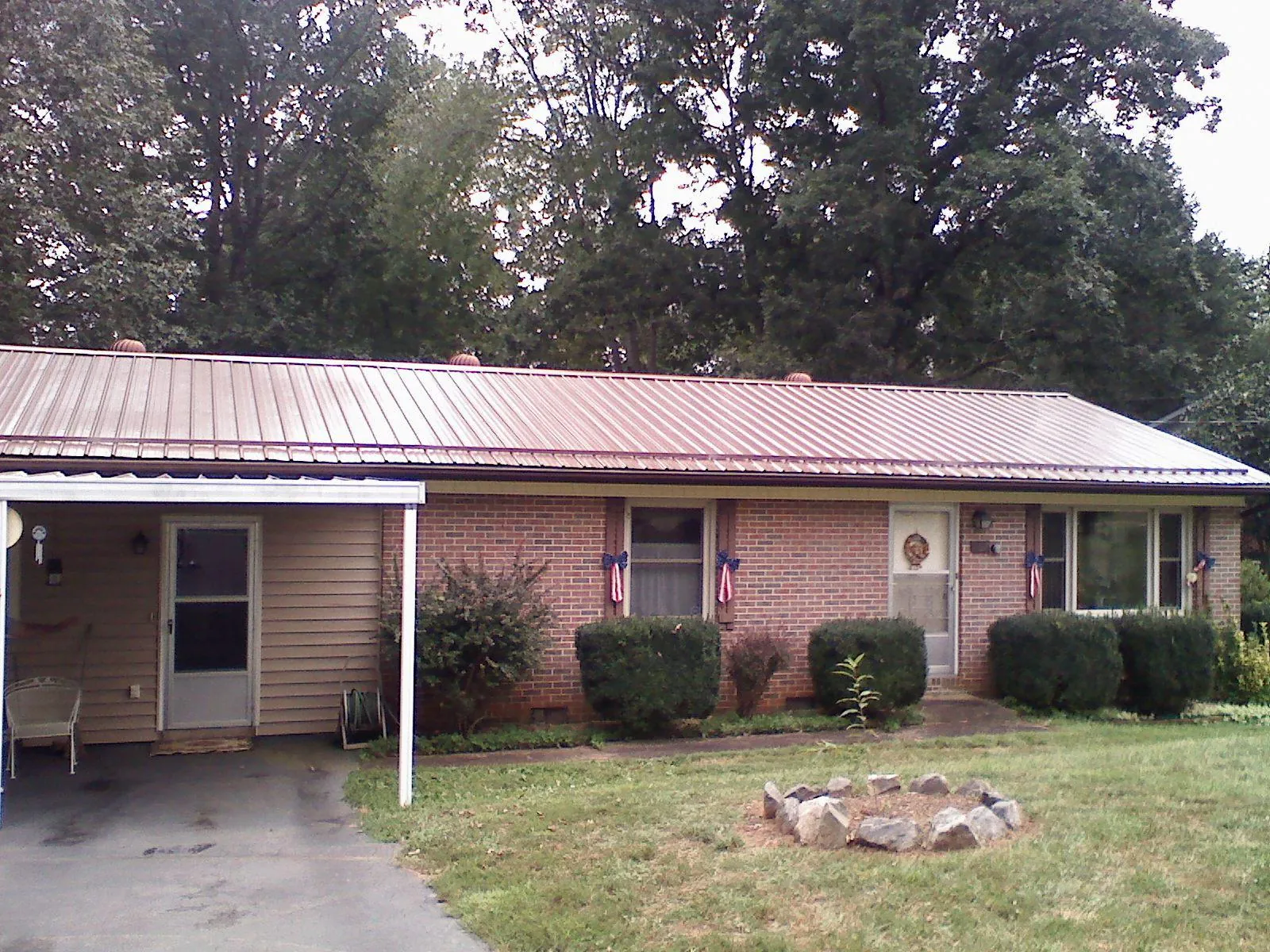 Bronze metal roof and carport on a brick ranch home — Roof Repair work by our crew in Kauneonga Lake